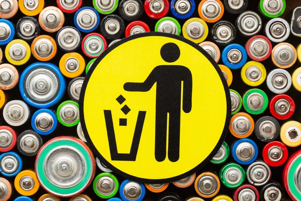A recycling logo covered in batteries
