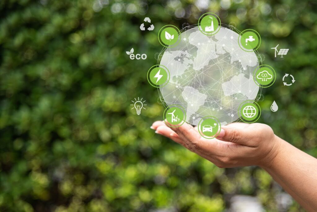 Concept art illustrating environmental sustainability and green energy, featuring hands supporting a digital globe connected to icons for wind power, electric vehicles, recycling, and CO2 reduction